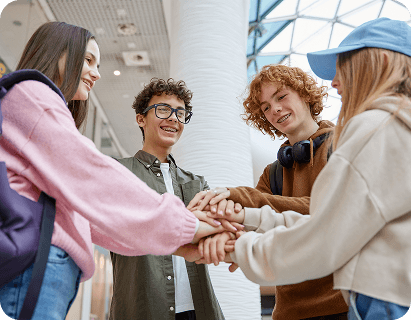 Students stacking hands in a school hallway
